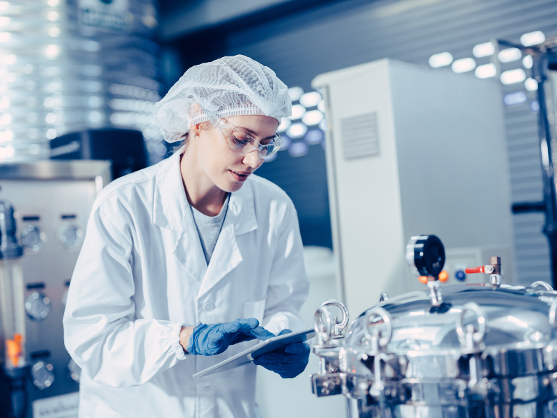 A biotech engineer verifying details in a US-based facility owned by MFG One, a leading provider of turnkey biotechnology manufacturing services.