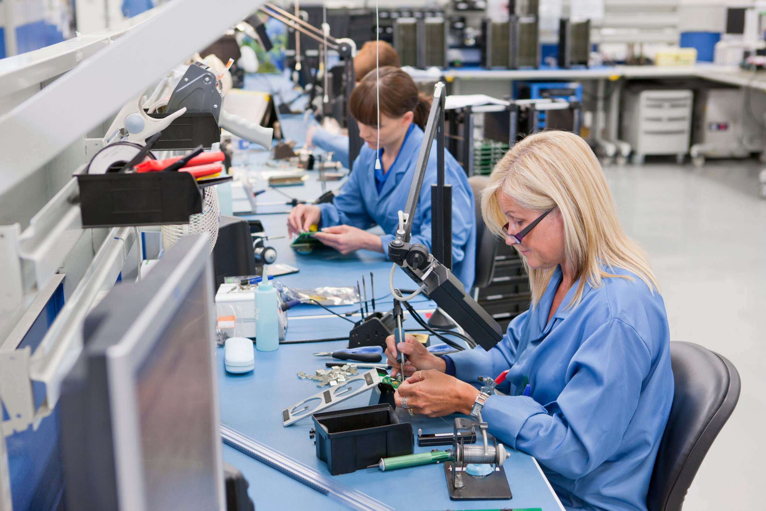 Featuring two women working at a Full service contract manufacturing facility in an electronic assembly line