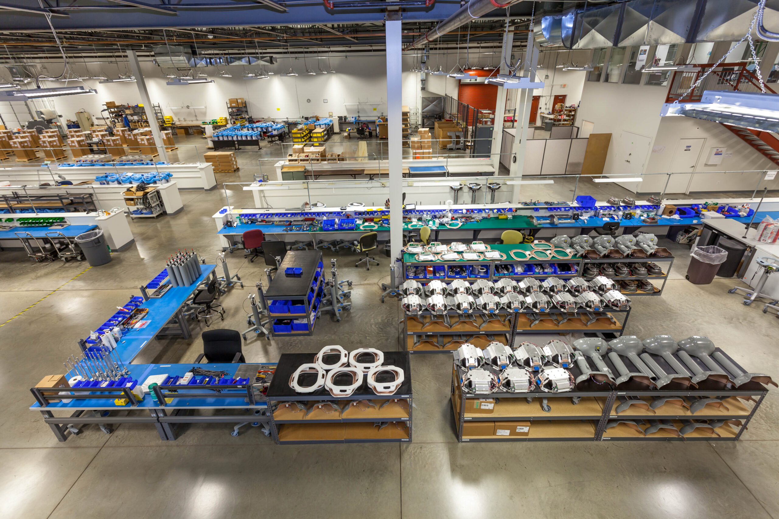 Engineers carefully building a custom product inside a turnkey production manufacturing facility, showing full assembly line.