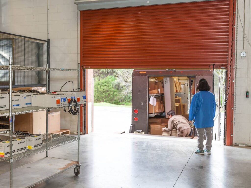 Warehouse workers loading boxes onto a delivery truck for fast electronic fulfillment services.